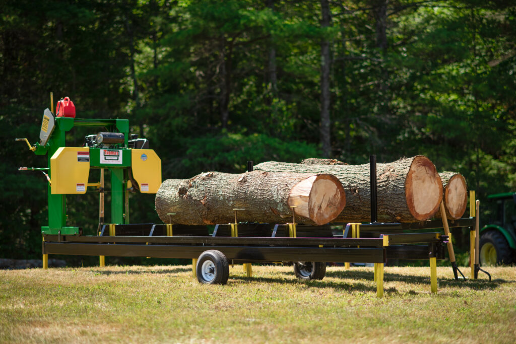 A log trailer with logs on it and a tree.