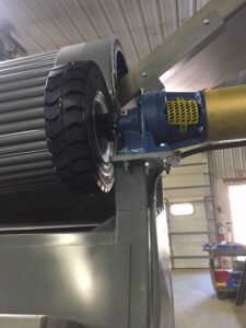 A tire being lifted by a machine in a garage.